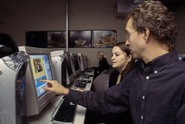 Photograph of faculty member and student in Journalism lab