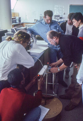 Photograph of a faculty member demonstrating the use of a laser device