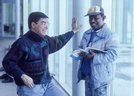 Photograph of two students interacting in the hallway