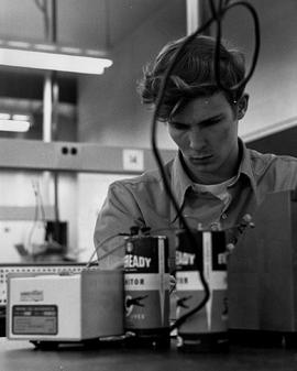 Photograph of a Technology Student Using Large Batteries in the Electronics Lab