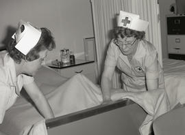 Photograph of nurses making the bed