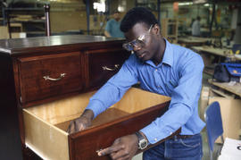 Photograph of a Student Working on a Cabinet in the Lab