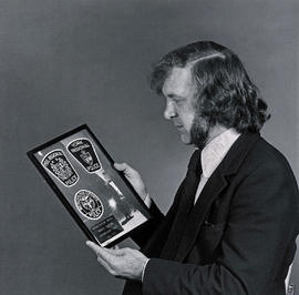 Photograph of Barry Saxton Holding an Award From the Local Police Services