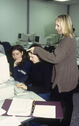 A photograph of three students working together at computer