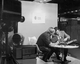 Photograph of Jerry Milan looking at a New Camera with a Technician