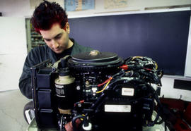 Photograph of student working on a small engine