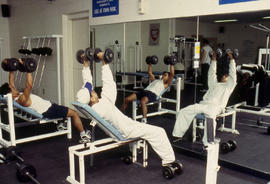 A photograph of students weight lifting on benches