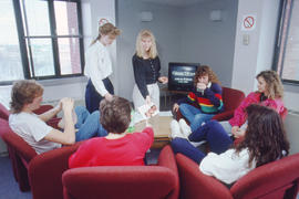 Photograph of a presenter and students in a meeting lounge of he residence building