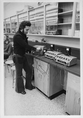 Photograph of an Electronics Student using Multiple Power Resistors in an Experiment
