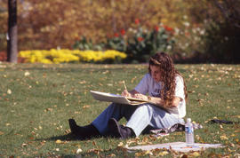 Photograph of a student working at sketching in the Arboretum
