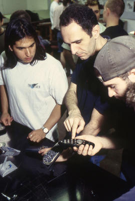 A photograph of Industrial Design students examining design models
