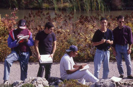 Photograph of students working at notes on a walkway in the Arboretum