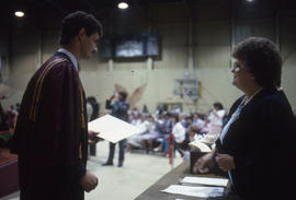 Photograph of a Graduate student holding a Diploma