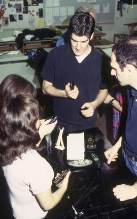 A photograph of Industrial Design students examining each other's designs