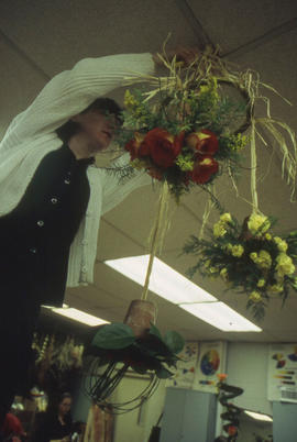 A photograph of a Retail Floriculture student building a floral arrangement