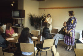 Photograph of persons seated and listening to a speaker at the podium