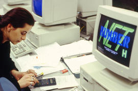 Photograph of a student working on a calculator in a computer lab