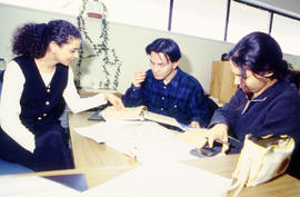 Photograph of Kiranjit Kenth assisting two students in her office