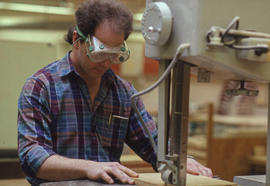 Photograph of Industrial Design student cutting wood at a band saw