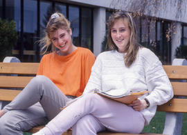 Photograph of two students sitting on a bench