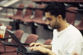 A photograph of a student working on a laptop