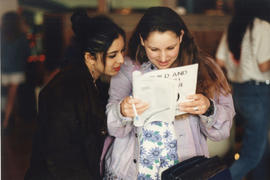 Photograph of two students looking through a book together