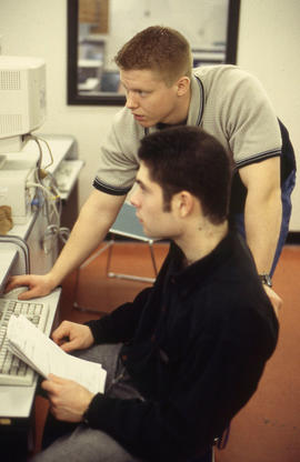 A photograph of two students working at a computer together