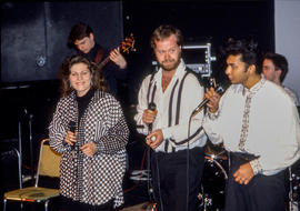 Photograph of three singers performing on stage together