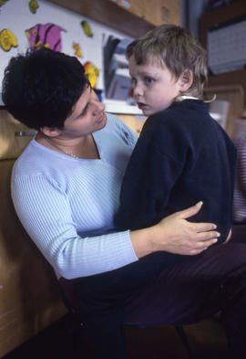 Photograph of an early childhood educator with a child in her lap