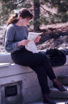 Photograph of a student reading the student newspaper 'Coven'.