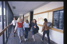 Photograph of people walking along the D building front hallway