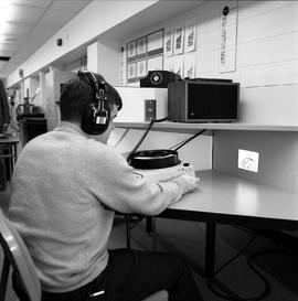 Photograph of a student using a multo-media resource at a study carrel in the library