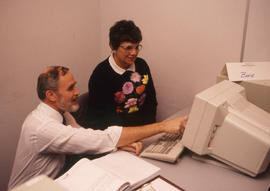 Photograph of Jim Hardy working next to a student at a computer