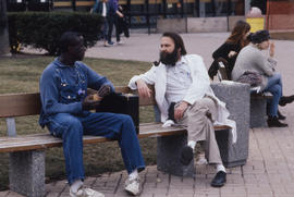 Photograph of an instructor and student talking on a bench