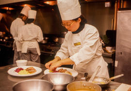 Photograph of a student in the Culinary program, plating food