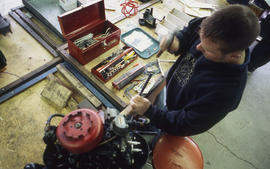 Photograph of student repairing a small engine