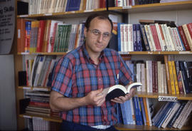 Photograph of a Faculty Member Holding a Book in the Human Studies Writing Centre