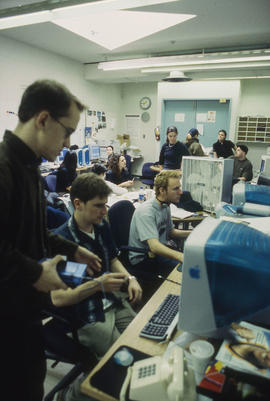 Photograph of a faculty member assisting students on the computer