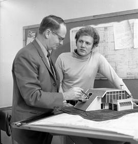 Photograph of Fred Irving working with a student to complete an architectural model