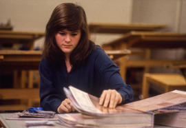 Photograph of a student flipping through a binder