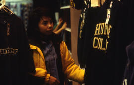 A photograph of a student looking at Humber branded clothing