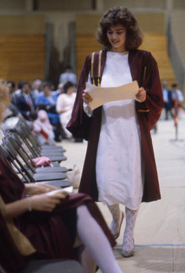 Photograph of a Graduate returning to her seat after receiving her diploma