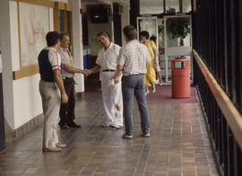 Photograph of persons in a discussion in the hallway