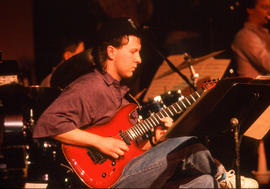 Photograph of a student musician playing a guitar