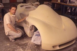 Photograph of an Industrial Design program student with a model car