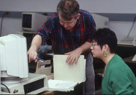 Photograph of an Instructor assisting a student in a technology computer lab