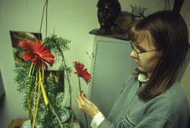 A photograph of a Retail Floriculture student preparing a floral arrangement