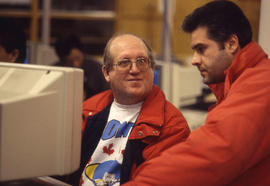 Photograph of two students collaborating at a PC workstation in an unknown lab