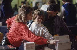Photograph of persons looking at some books