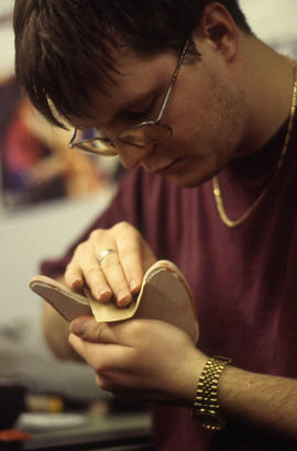 A photograph of an Industrial Design student sanding their product design
